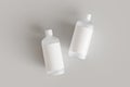 Two plastic cosmetic containers with labels, shampoo bottles laying on gray background front view 3D render mockup