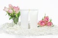 Two plastic cosmetic tubes on white background with flowers and soft paper filler, mockup, Day and night care, beauty product