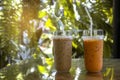 Two plastic take away cup of iced coffee latte and milk tea on wood table outdoors garden at coffee shop Royalty Free Stock Photo