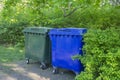 Two plastic trash containers. The containers are located in the city park. Separate sorting of waste. Responsible Royalty Free Stock Photo