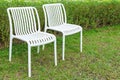 Two plastic white chairs in the garden