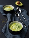 Two plates with cream soup of cucumbers and avocado on dark background. Flat lay Royalty Free Stock Photo