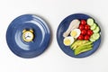 Plates with food and alarm clock on white background, Interval fasting concept Royalty Free Stock Photo