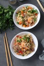 Two plates fried rice with seafood, vegetables, ginger and parsley on dark background. Asian cuisine. Vegetarian food. Vertical Royalty Free Stock Photo