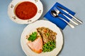 Two plates, one with turkey, pea and buckwheat, second with goulash soup, cutlery and napkin Royalty Free Stock Photo