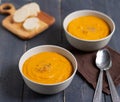 Two plates with pumpkin soup and spoons on a brown napkin Royalty Free Stock Photo