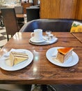 Two plates with different types of piece of cakes and a cup of coffee in a coffee shop Royalty Free Stock Photo