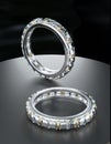 Two platinum diamond rings with diamonds surrounding the ring. Ring design on black surface with 3D Royalty Free Stock Photo