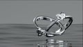 Two platinum diamond rings float on the surface of the water. Heart diamond rings design with 3D Royalty Free Stock Photo