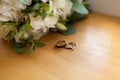 Two platinum wedding rings on wood background with flowers. Bride ring with diamonds. Shallow focus. Rustic wed concept