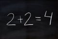 two plus two equals four, written on a blackboard Royalty Free Stock Photo