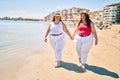 Two plus size overweight sisters twins women happy at the beach on summer holidays Royalty Free Stock Photo