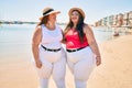 Two plus size overweight sisters twins women happy at the beach on summer holidays Royalty Free Stock Photo