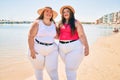 Two plus size overweight sisters twins women happy at the beach on summer holidays Royalty Free Stock Photo