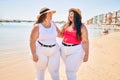 Two plus size overweight sisters twins women happy at the beach on summer holidays Royalty Free Stock Photo