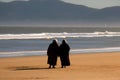 Two plus size overweight sisters twins women happy and proud of their bodies walking at the beach on summer holidays Royalty Free Stock Photo