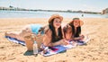 Two plus size overweight sisters twins women relaxing lying on a towel at the beach on summer holidays