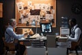 Two police detectives sitting at desk in office on opposite sides