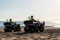 Two police officers patrol deserted beach at dawn in Valencia