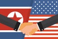 Two politicians handshake in front of an American and North Korean flags. Two flags face to face, symbol for the