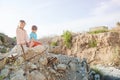 Two poor refugee children boy girl on ruins building destroyed by air strike