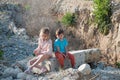 Two poor refugee children boy girl on ruins building destroyed by bombing