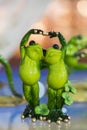 Two porcelain figures of dancing toads. Dancing toads. vertical photo
