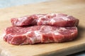 Two pork meat steaks, on a cutting board