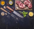 Two pork steak on a cutting board with butter and garlic, border, place for text on wooden rustic background top view Royalty Free Stock Photo