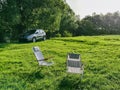 two portables chairs at green field suv car on background