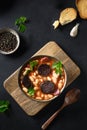 Spanish asturiana fabada with chorizo and morcilla on black background.