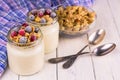 Two portions of fresh yogurt with frozen berries and granola on a white wooden table. Close-up. Royalty Free Stock Photo