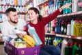 Two positive adult people in good spirits selecting detergents i Royalty Free Stock Photo