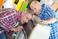 Two positive cheerful workers working on machine Royalty Free Stock Photo