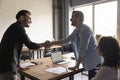 Two positive confident businessmen shaking hands over meeting table Royalty Free Stock Photo