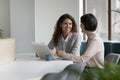 Two positive confident diverse business colleagues women talking at workplace Royalty Free Stock Photo