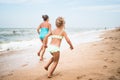 Two positive little girls run along sandy beach Royalty Free Stock Photo