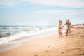 Two positive little girls run along sandy beach Royalty Free Stock Photo