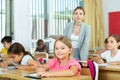 Two positive small school girls sitting together in classroom Royalty Free Stock Photo