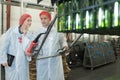Two positive workers in white coats on beer brewery factory Royalty Free Stock Photo
