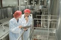 Two positive workers in white coats at factory Royalty Free Stock Photo