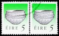 Two postage stamps printed in Ireland shows Dunamase Food Vessel (Early Bronze Age), Irish Heritage and Treasures serie, 5 p -