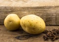 Two potatoes close up on wood with star anise Royalty Free Stock Photo