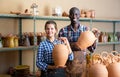 Two potters posing in pottery workshop