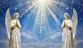 Two praying angels with rays of light over blue sky with stars with copy space in center Royalty Free Stock Photo