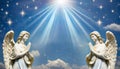 Two praying angels with rays of light over blue sky with stars with copy space in center Royalty Free Stock Photo