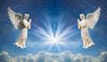 Two praying angels with rays of light over blue sky with stars with copy space in center Royalty Free Stock Photo