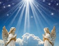 Two praying angels with rays of light over blue sky with stars with copy space in center Royalty Free Stock Photo