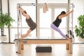 Two pregnant women are doing Pilates on a Cadillac reformer. Royalty Free Stock Photo