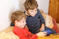 Two preschool or school kids boys, siblings and brothers having fun after school day playing video game at home and Royalty Free Stock Photo